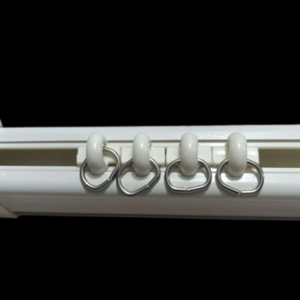 White aluminum jumbo silent curtain track with four gliding rollers and metal hooks, designed for smooth and quiet operation.