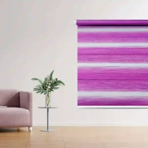 Vibrant pink Zebra Window Blind with bold horizontal stripes, installed in a chic living room featuring a blush armchair and a decorative side table with a vase of greenery.