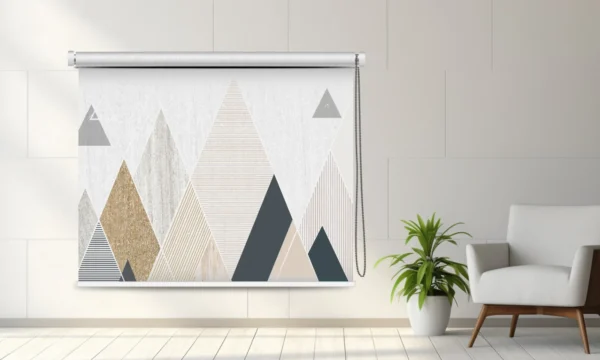 Modern geometric roller blind with triangular patterns in beige, gray, and white, displayed in a bright minimalist room.