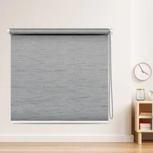 Textured gray blackout roller blind with a chain mechanism in a modern living room setup.